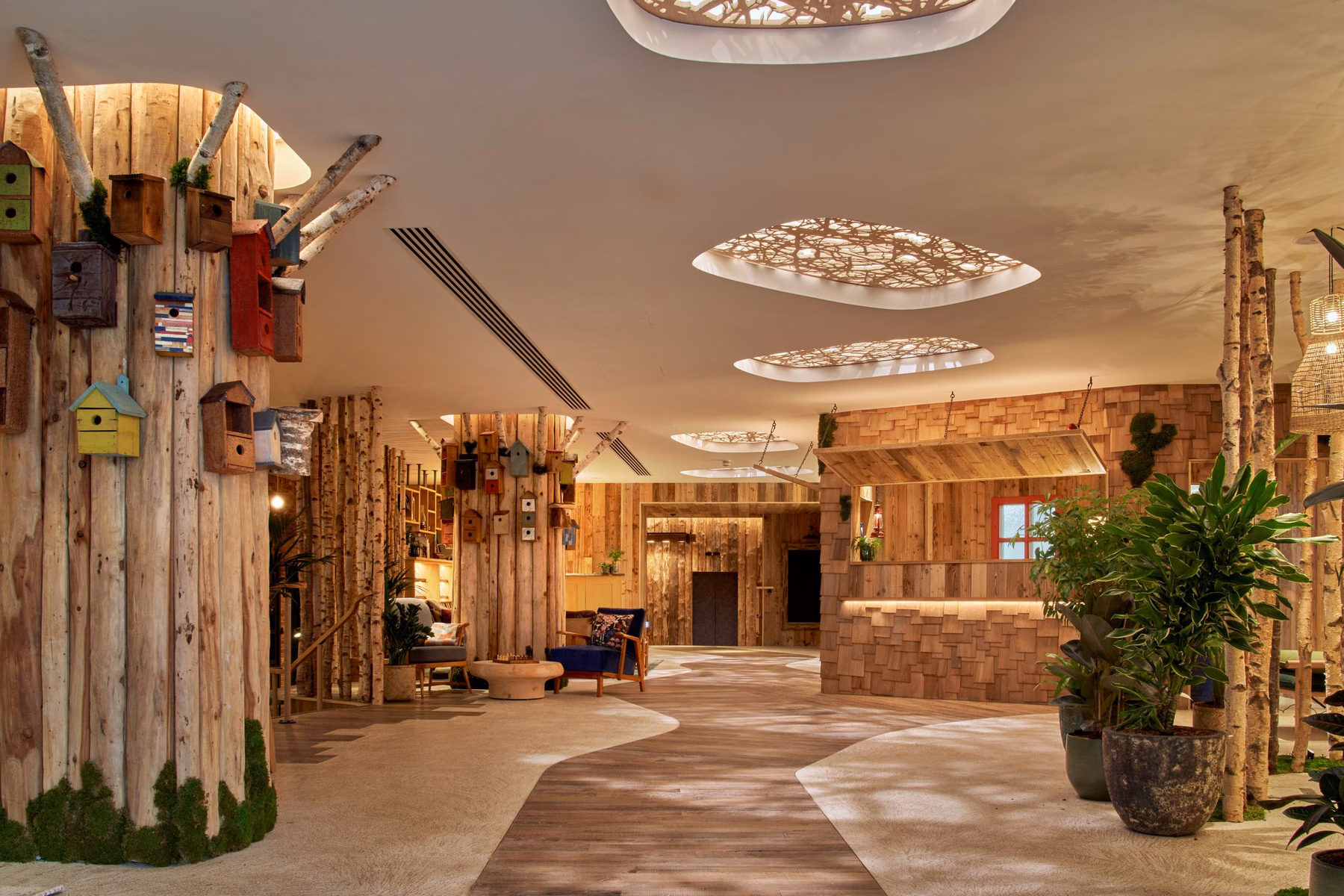 The Treehouse Hotel lobby extends a natural motif through timber walls, birdhouse decorations, and branch elements. Photo / Supplied by Treehouse Hotels
