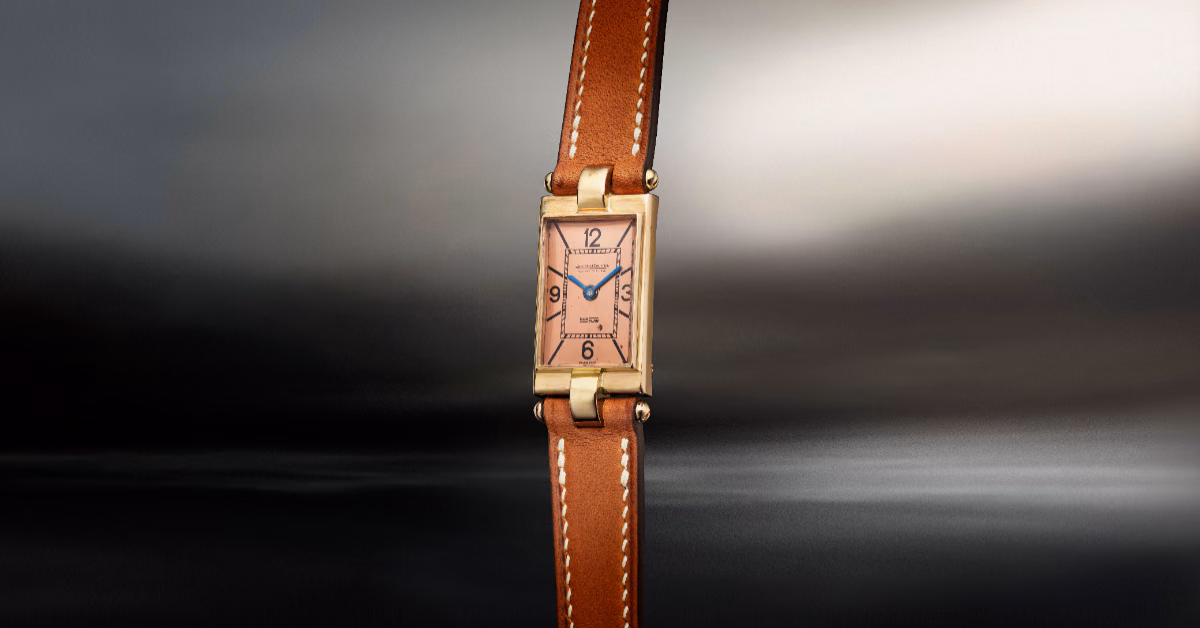 A vintage timepiece featuring a copper-toned dial and a brown leather strap.