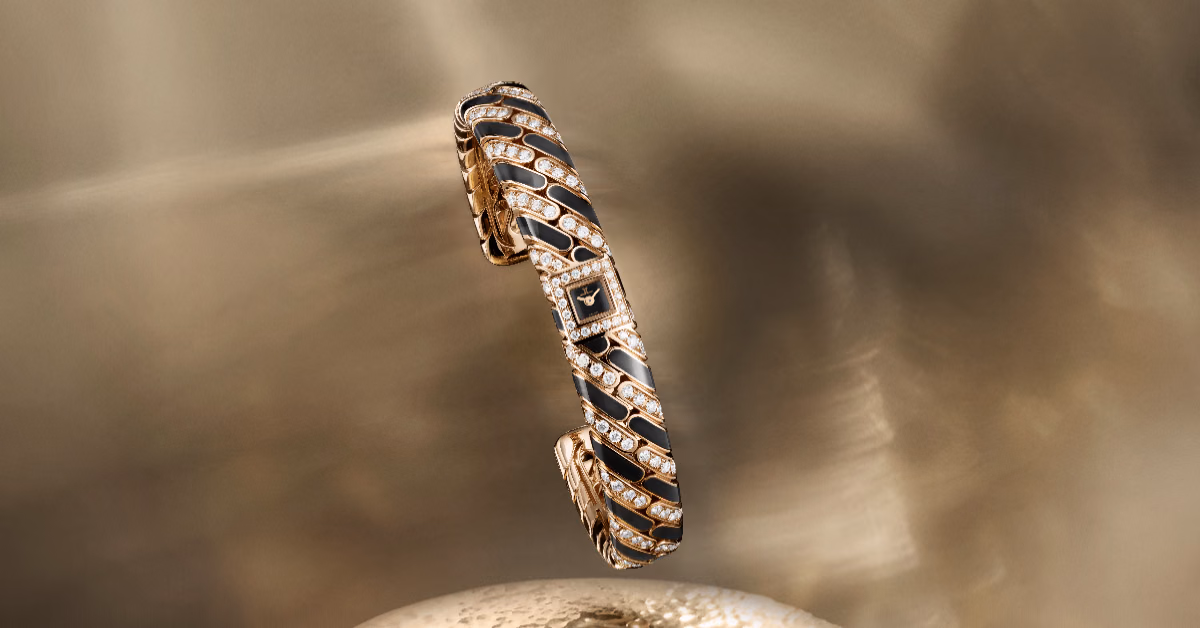The Calibre 101 Chain bracelet watch forms a three-dimensional silhouette with golden links, diamonds, and black details.