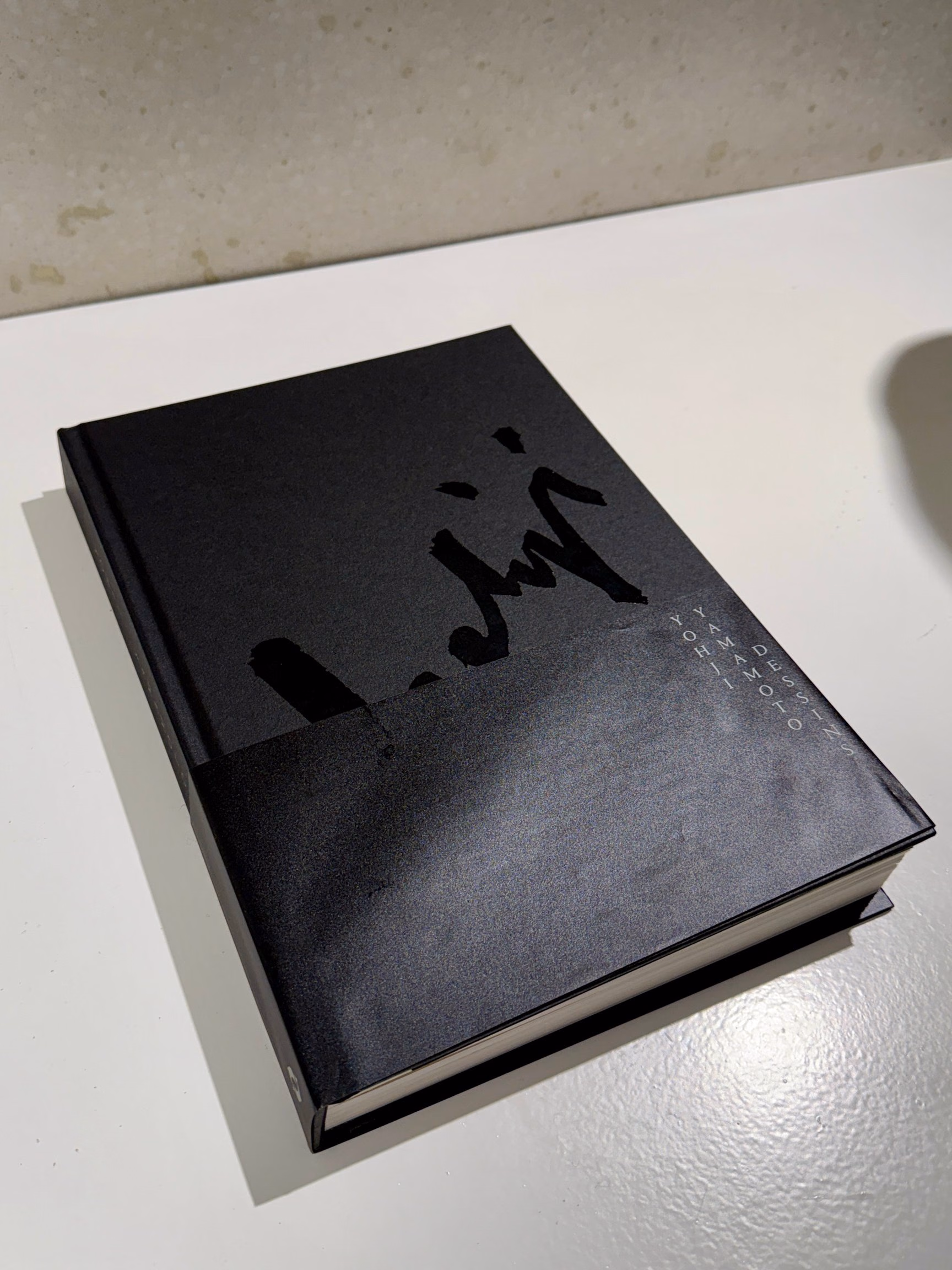 광택이 다른 도형이 놓인 Yohji Yamamoto Drawings 검은 표지
