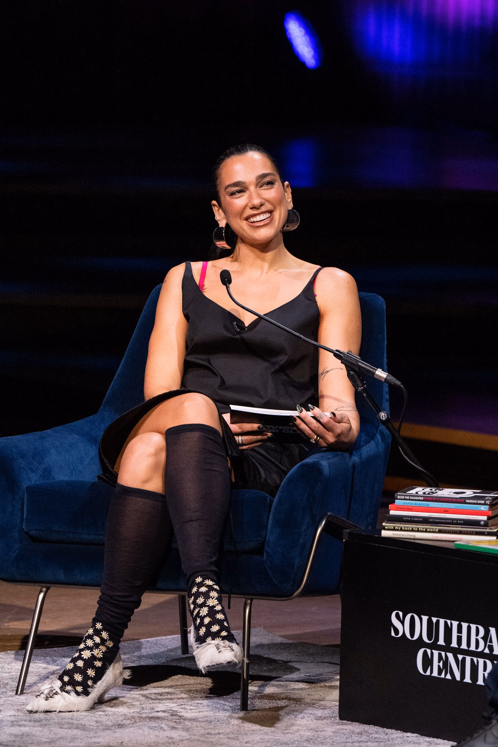 Dua Lipa ใส่ชุดแยกชิ้นสีดำ ถุงเท้าลายเดซี่ และส้นสูงขาวแต่งขนนก