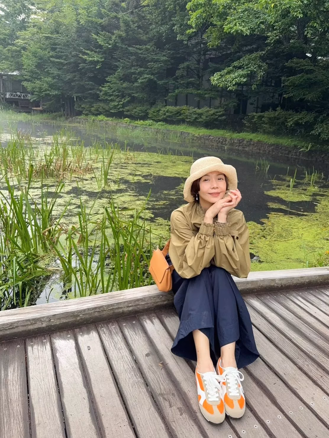 屋外の帽子とオリーブ色の羽織りの于子育