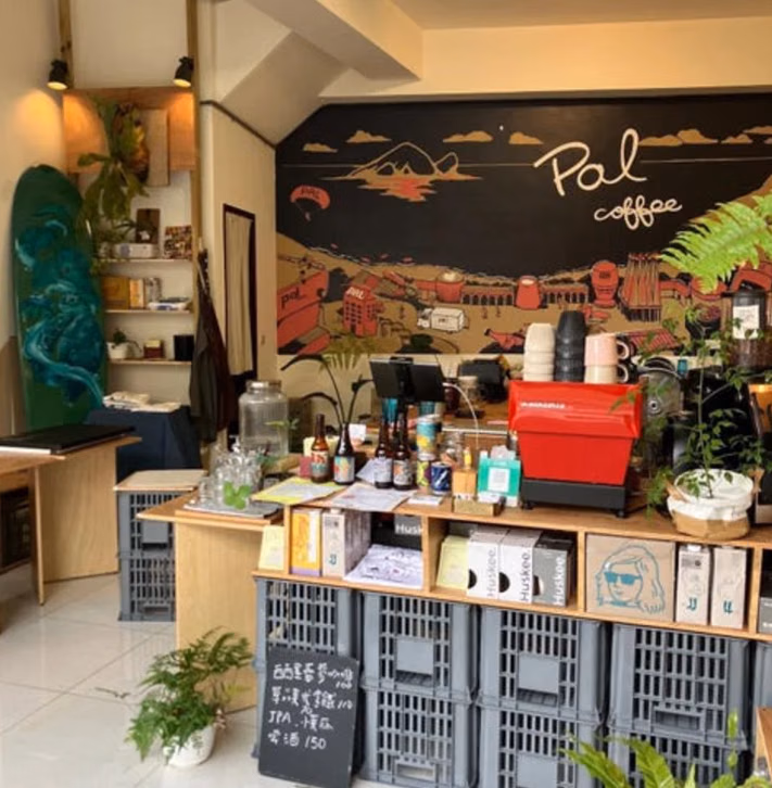 Pal Coffee 매장 안의 빨간 커피 머신·카운터·벽 그림