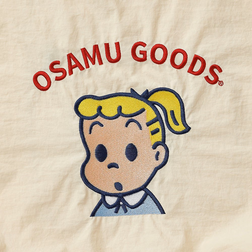 ลายปักจิลเดี่ยวบนผ้างาช้างและข้อความ OSAMU GOODS สีแดง