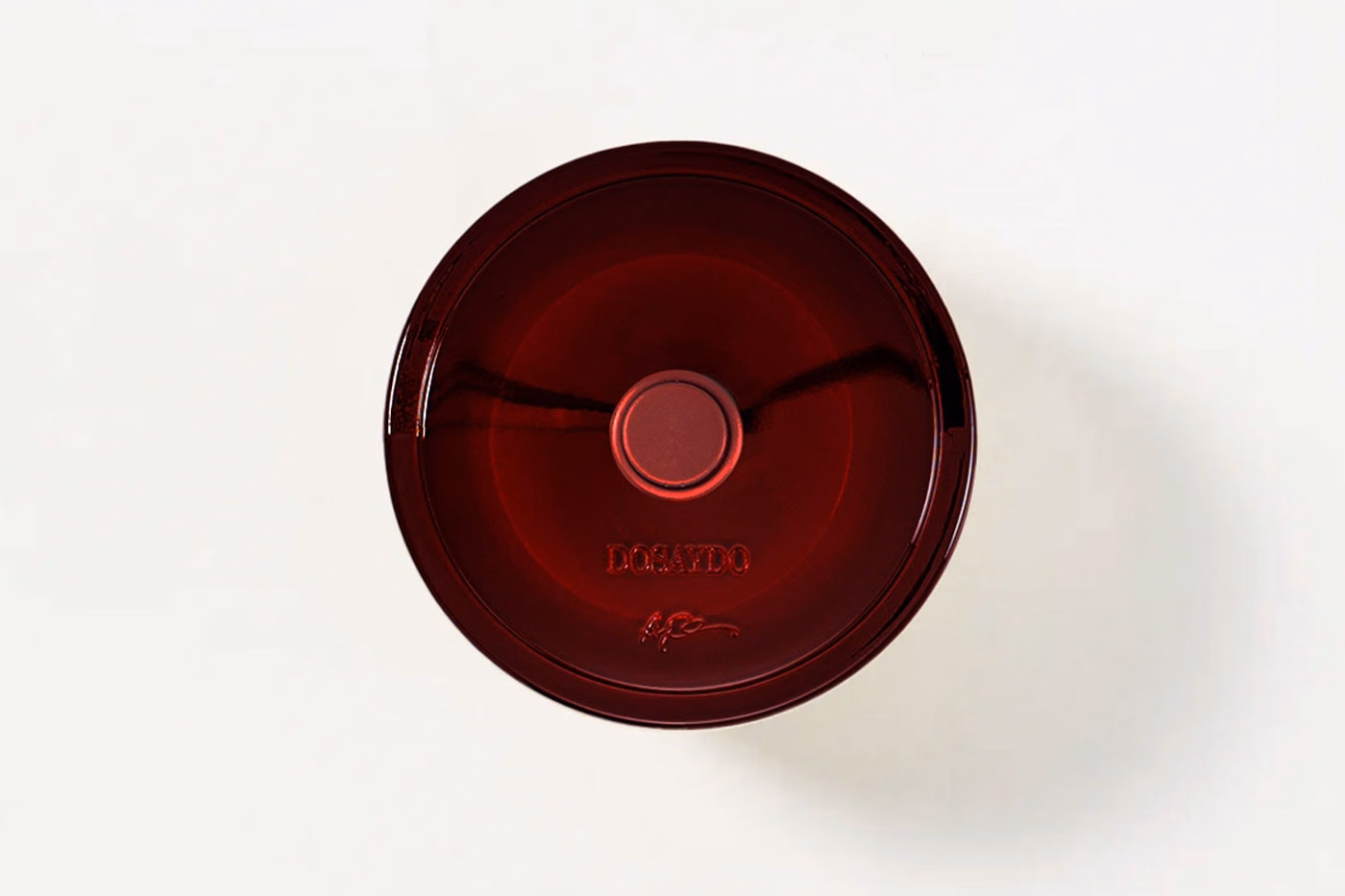 Burgundy circular bottle view with DOSAYDO lettering and a small emblem