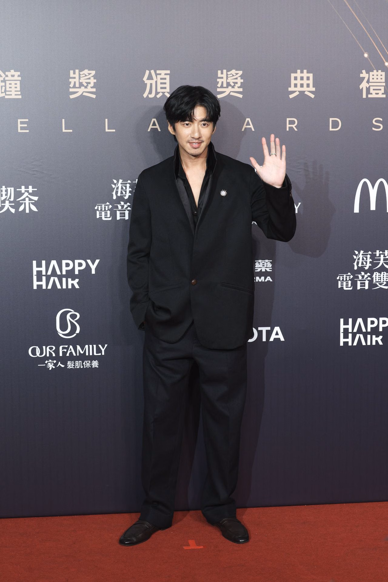Fu Meng-po waves in an all-black outfit with an open neckline and small brooch