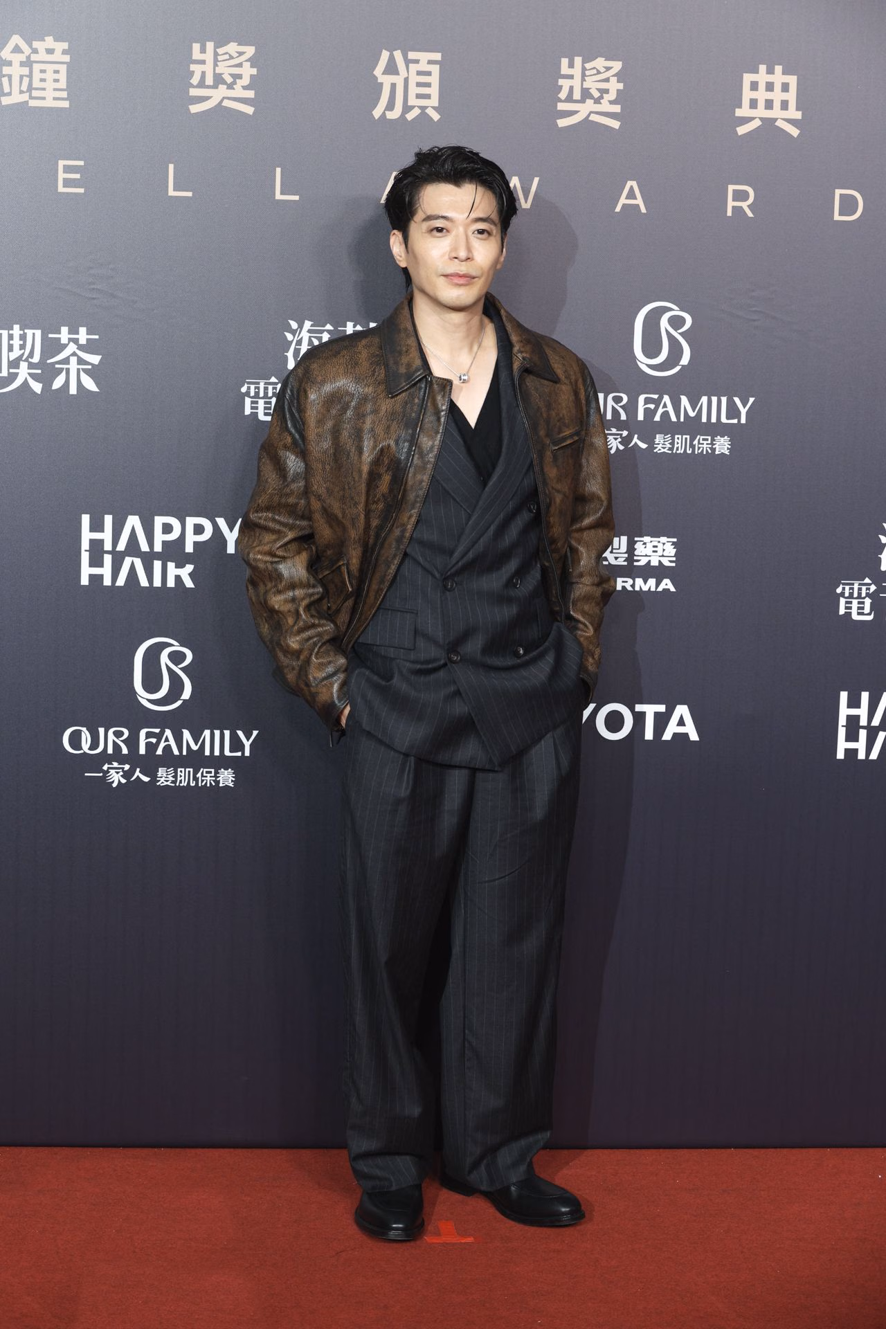 Hou Yen-hsi layers a brown leather jacket over a dark pinstriped double-breasted suit