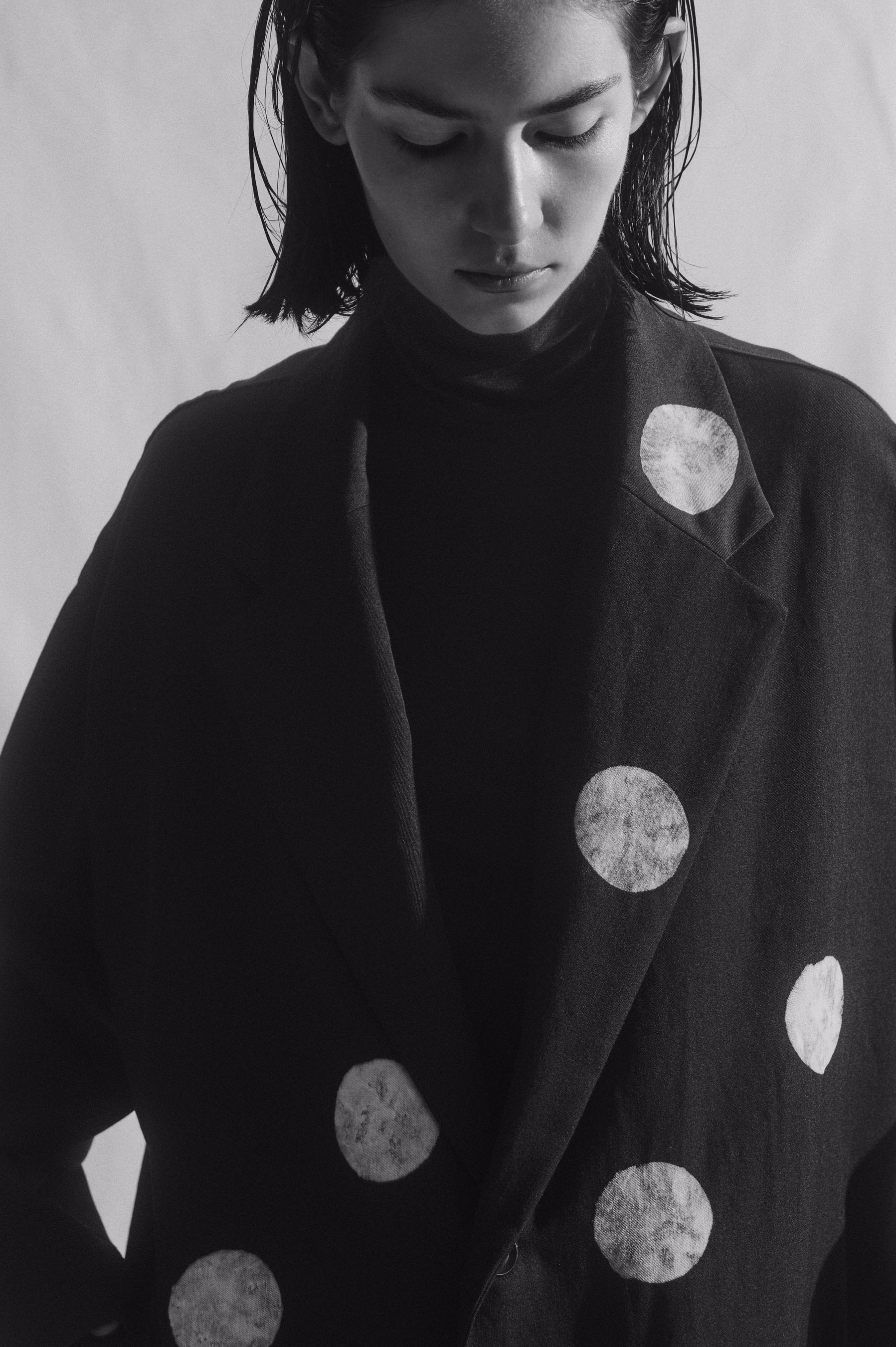 Pale dots scattered over a black wool jacket lapel and front