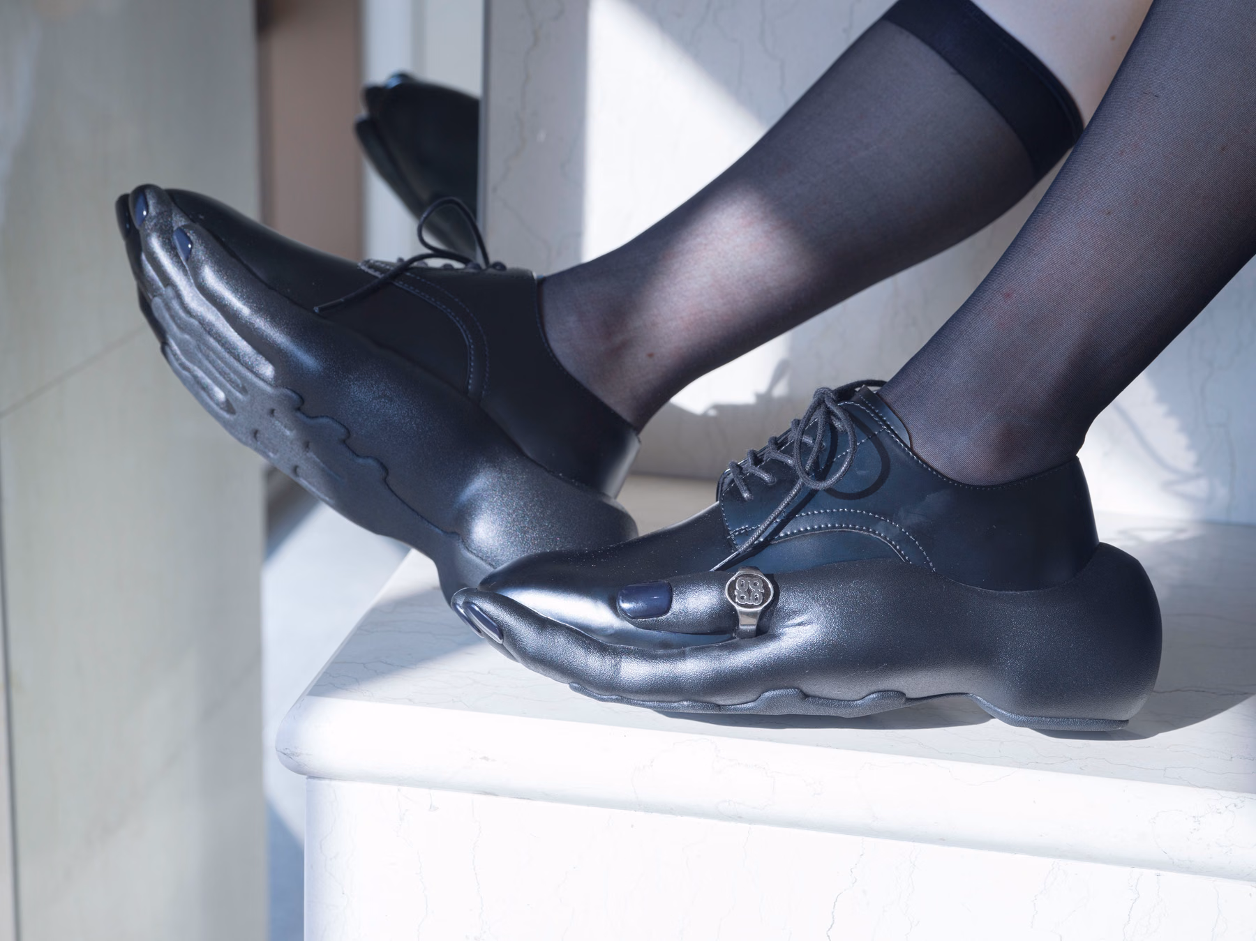 指とリングが見える黒い短靴の着用接写