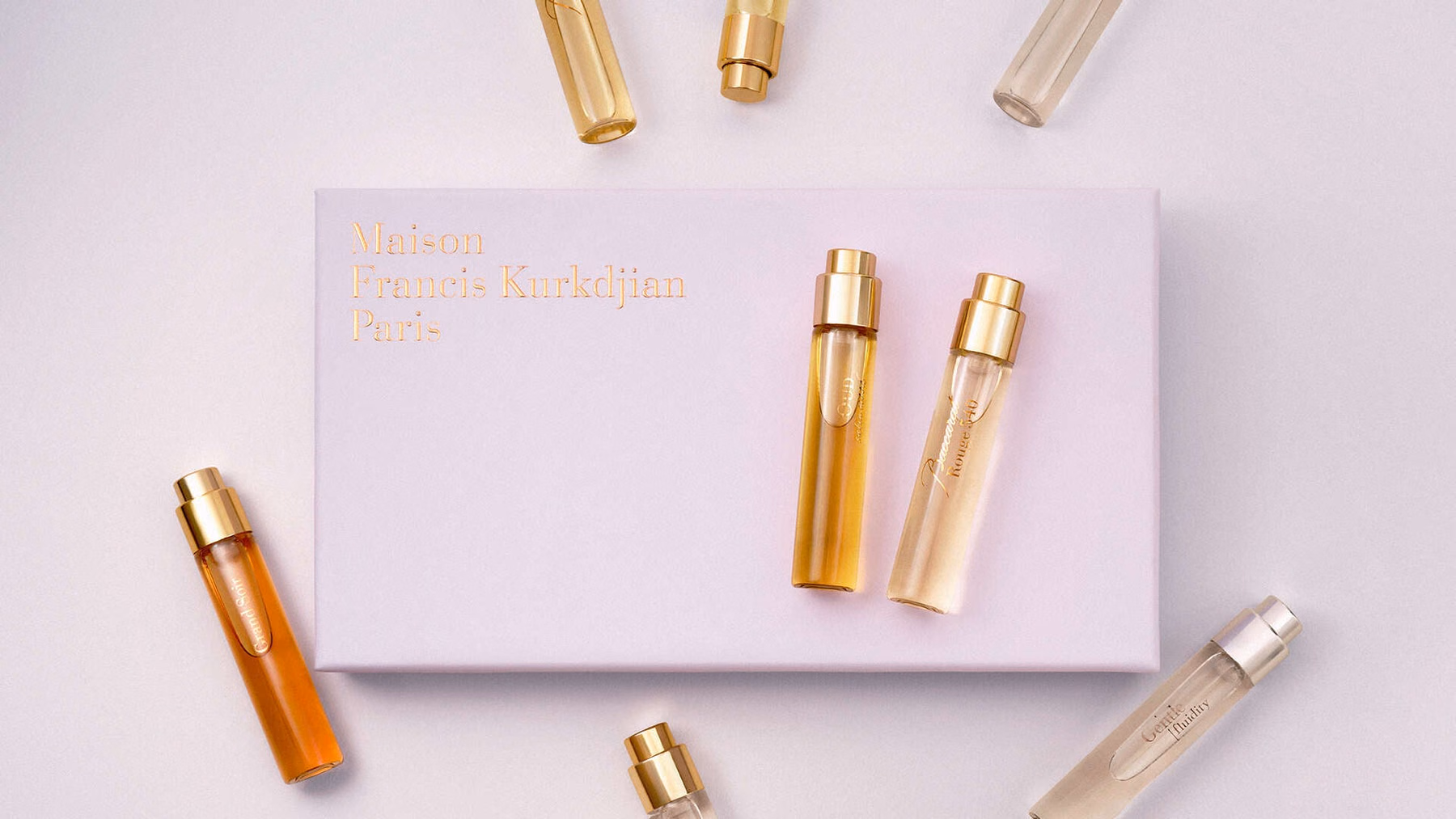 กล่อง MFK สีชมพูกับขวดน้ำหอมเดินทางวางแนวทแยง