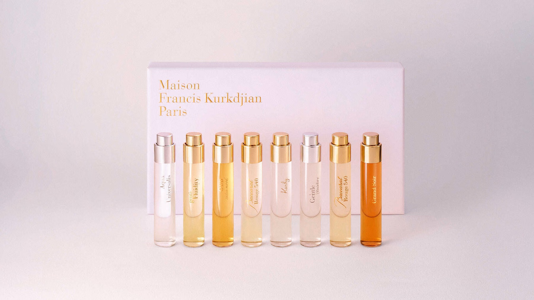 ขวดน้ำหอมเดินทางแปดขวดมีชื่อกลิ่นวางหน้ากล่อง MFK สีชมพู