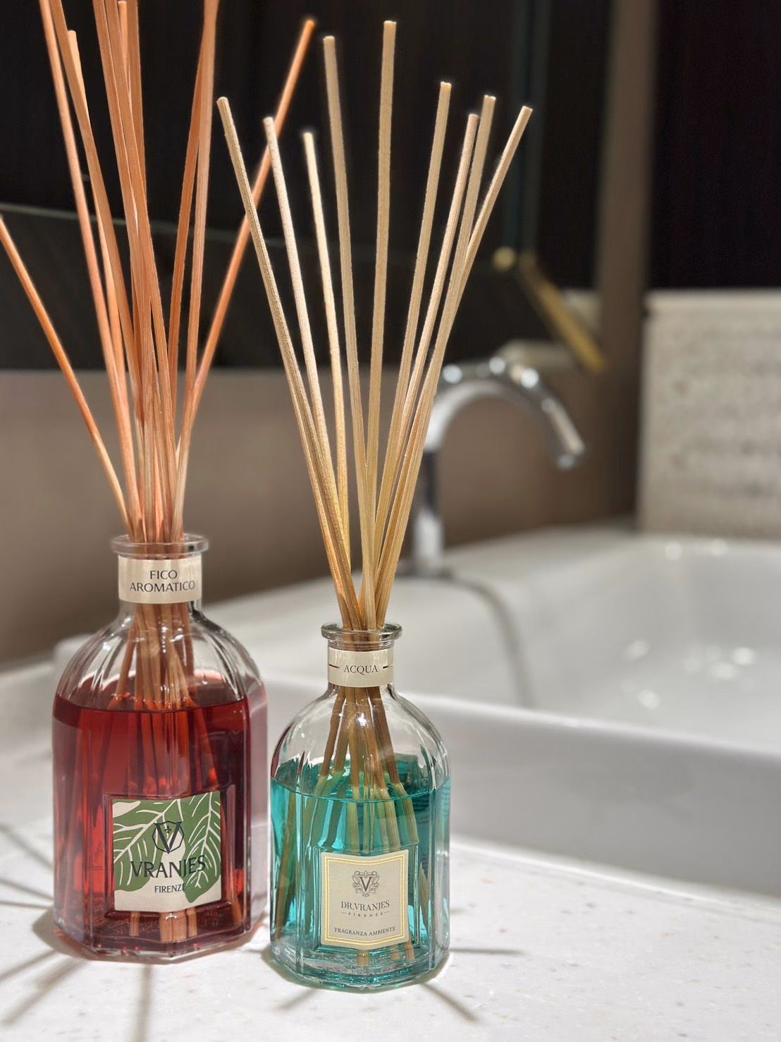 浴室のカウンターに置いた赤いFICO AROMATICOと緑のACQUA